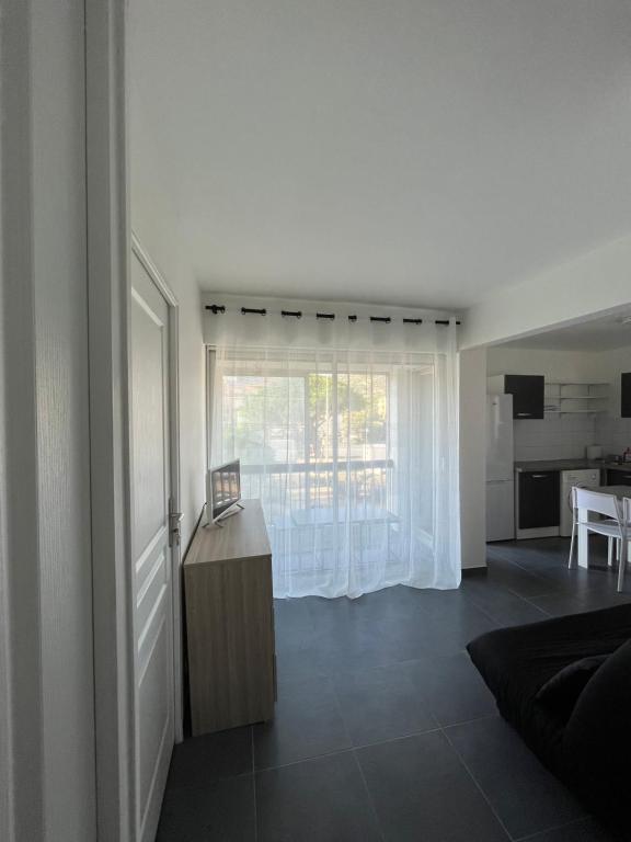 Il comprend un salon avec une grande fenêtre et une cuisine. dans l'établissement Appartement Caroline Proche mer & ville CALVI, à Calvi