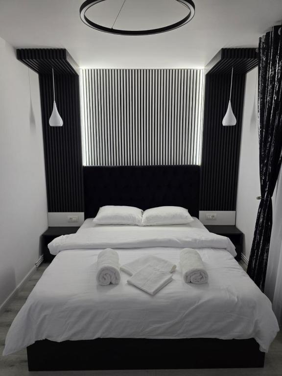 a bedroom with a large bed with towels on it at AIM & Residence in Piteşti