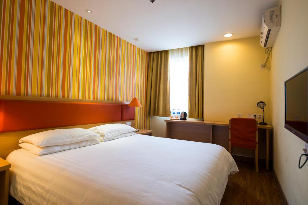 a hotel room with a bed and a television at Home Inn Shijiazhuang Railway Station West Square South Zhonghua Street in Shijiazhuang