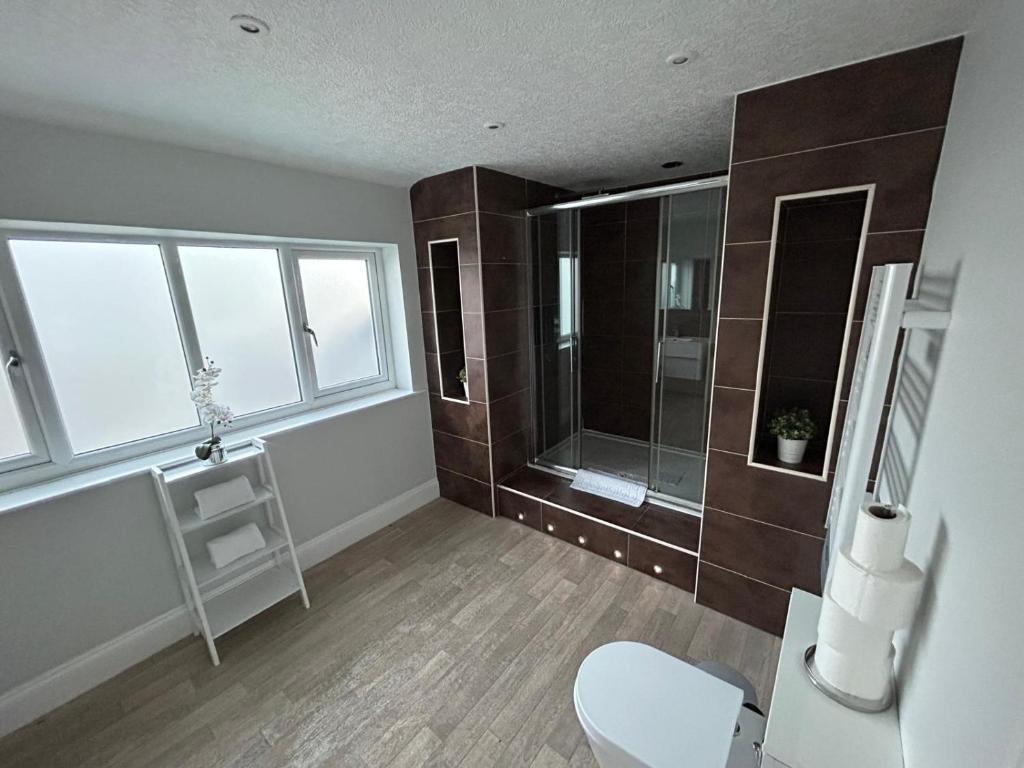 a bathroom with a shower and a toilet and a window at The PADhouse in York