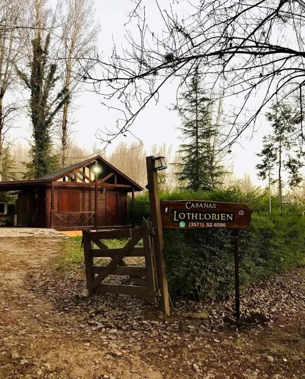 a sign in front of a log cabin at Cabañas Lothlorien in Villa Yacanto