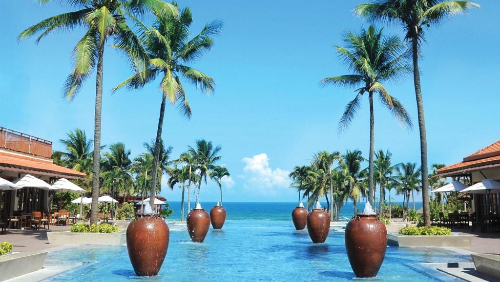 a pool at a resort with large vases in the water at Furama Resort Danang in Da Nang