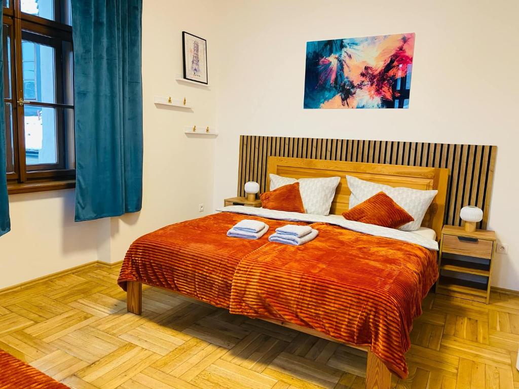 a bedroom with a bed with two towels on it at Stylový apartmán u Velkého náměstí 2, Wi-Fi, Netflix, vana in Hradec Králové