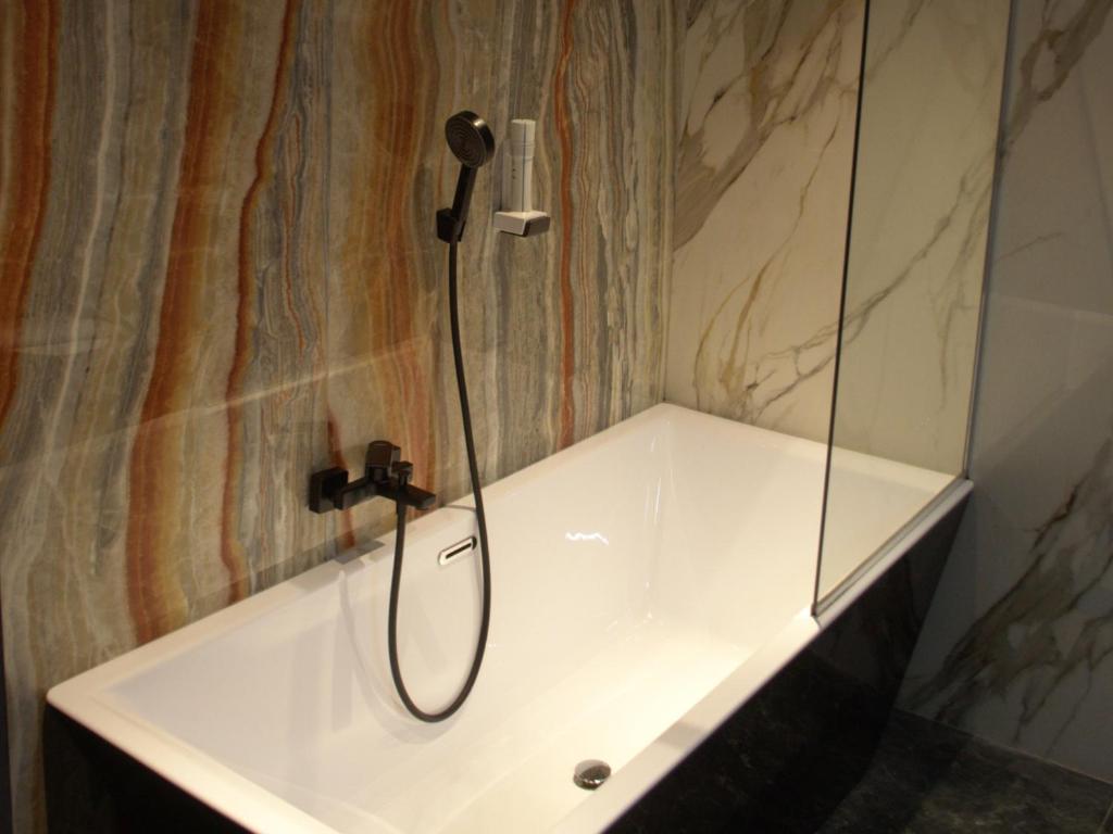 a shower in a bathroom with a white tub at Hotel EMD in Bacău