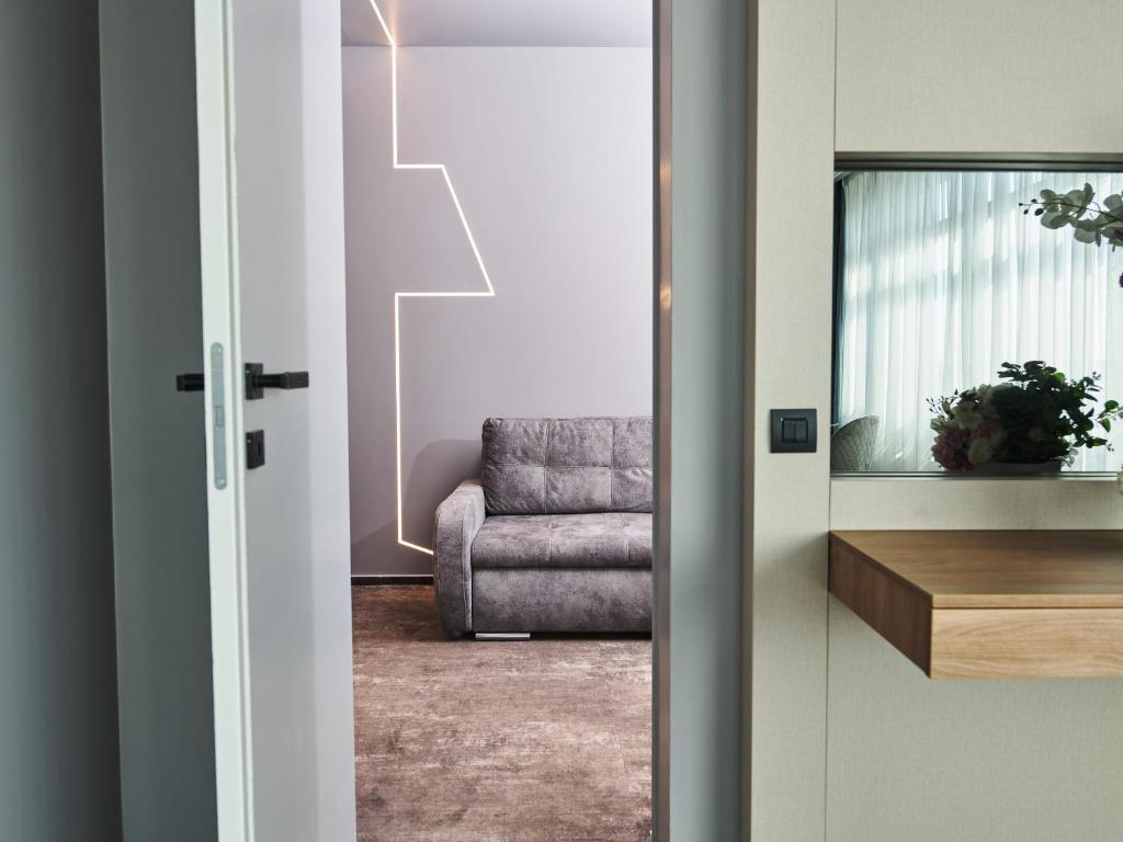 a door leading into a living room with a chair at Hotel EMD in Bacău
