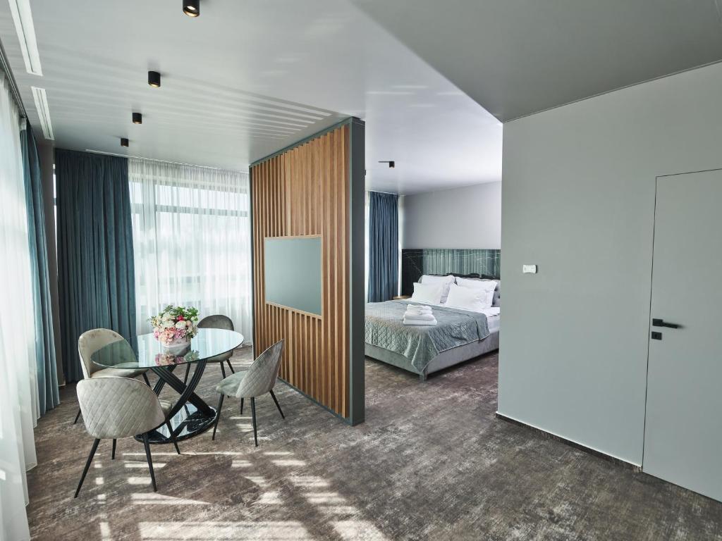 a hotel room with a bed and a table and chairs at Hotel EMD in Bacău