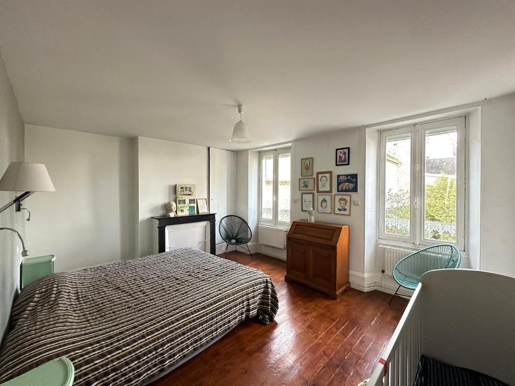 a bedroom with a bed and a dresser and windows at Maison familiale-jardin-50m du Loing-tout à pieds in Moret-sur-Loing