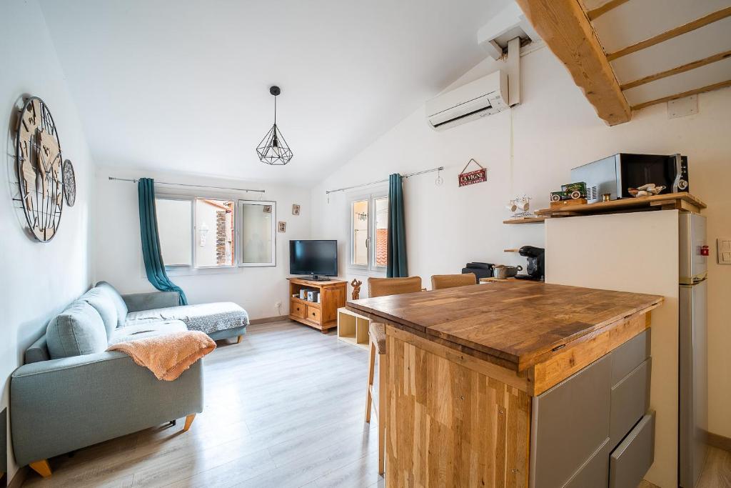 - une cuisine et un salon avec un comptoir et un canapé dans l'établissement Terroir et Mer - A 5min à pied de la plage, à Banyuls-sur-Mer