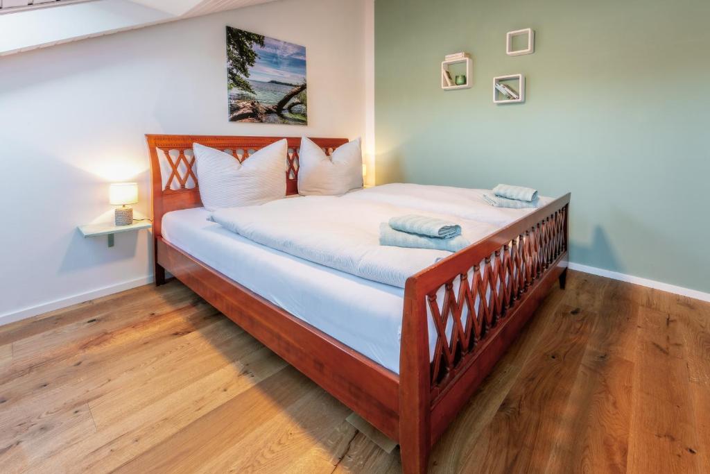 a bedroom with a wooden bed with white sheets at Fewo Sommernachtstraum in Gaienhofen
