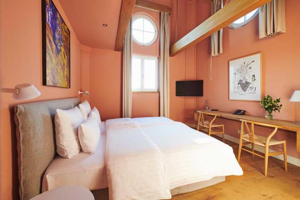 een slaapkamer met een bed en een bureau bij MOMA1890 Boutique Hotel in München