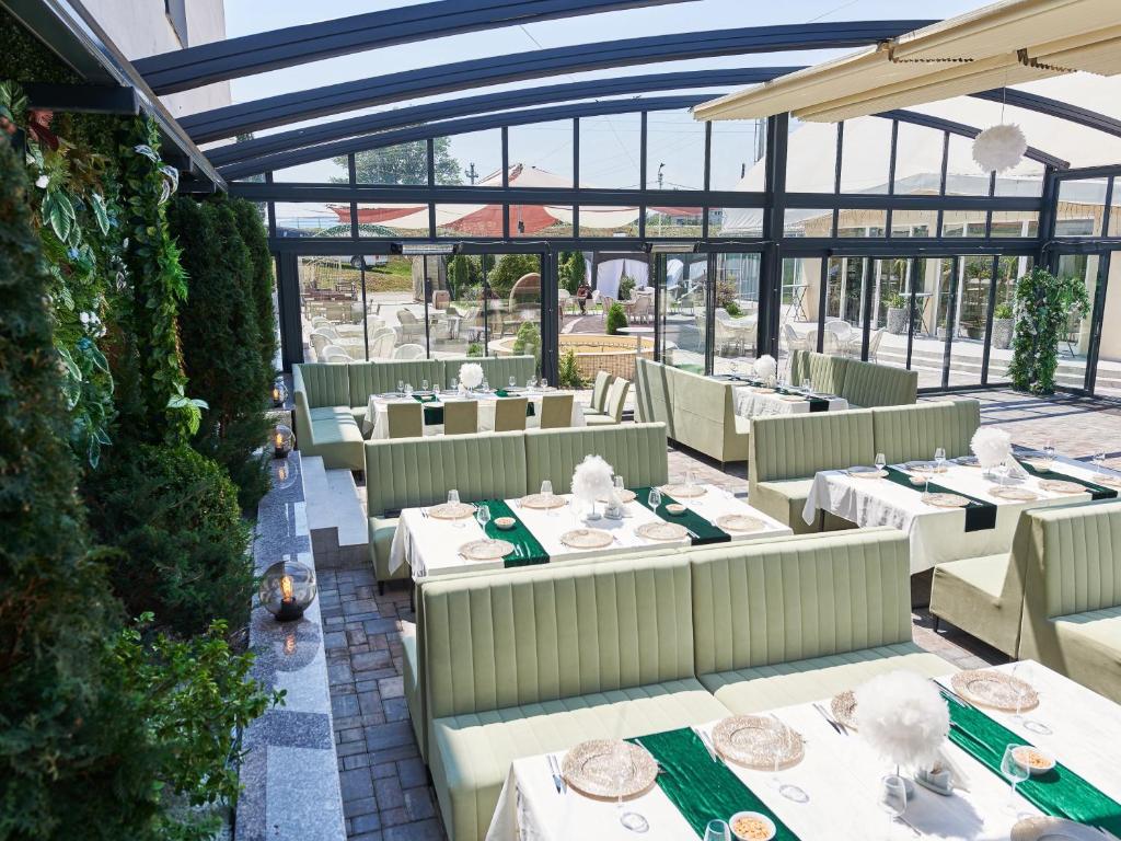 an empty restaurant with white tables and chairs at Hotel EMD in Bacău