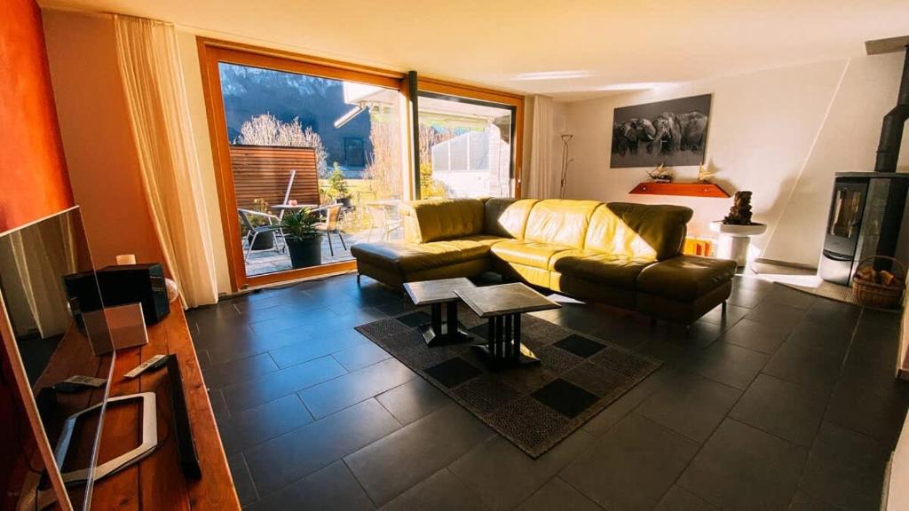 a living room with a couch and a table at Swiss House with Mountain Views in Meiringen