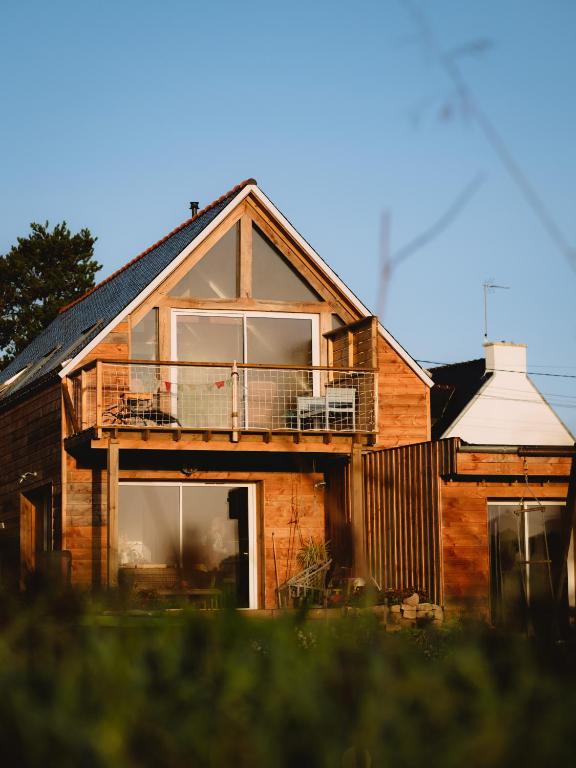 une maison avec un balcon sur le côté dans l'établissement Côte et Rôve Maison mignon au bord de mer, à Plouhinec