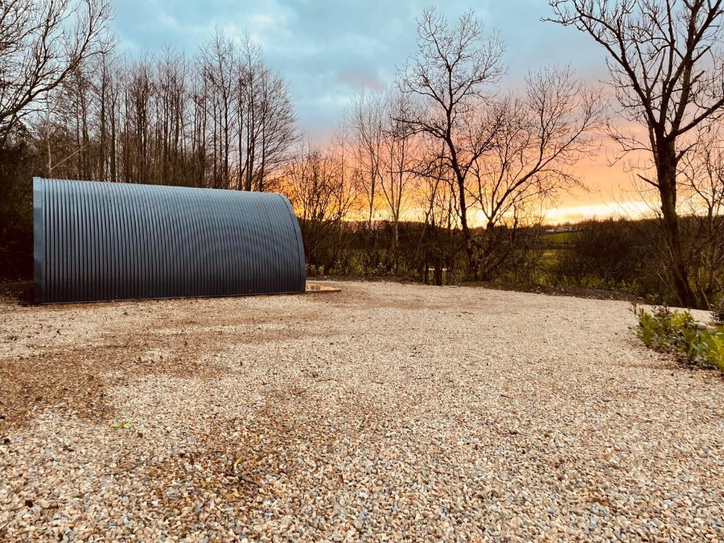 un grande oggetto metallico seduto su un campo di ghiaia di Executive Pod and Jacuzzi a Watch House Village