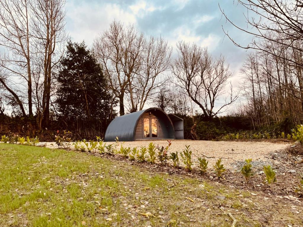 un piccolo edificio a forma di cupola in un campo alberato di Executive Pod and Jacuzzi a Watch House Village