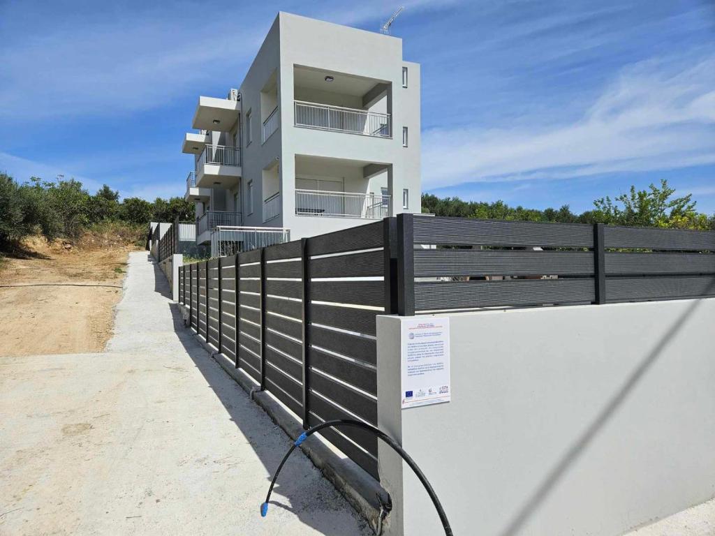 a white building with a black fence in front of it at Our Villa - Villa Rena in Rethymno Town