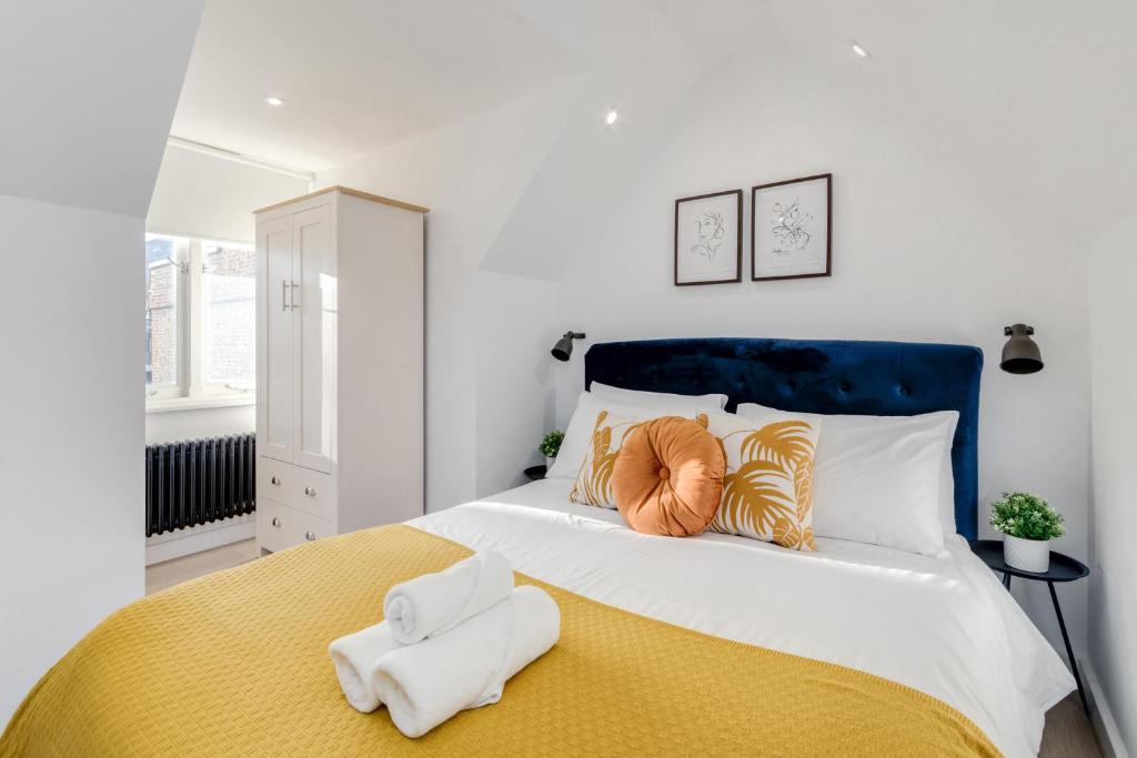 a bedroom with a large bed with a blue headboard at 1 Bedroom Penthouse Apartment - Shoreditch, London by The Perfect Stay in London