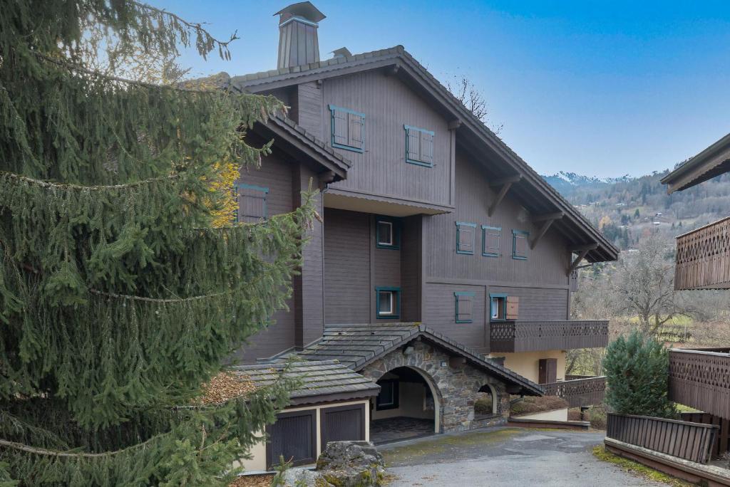 - une vue sur l'extérieur d'un bâtiment avec un arbre dans l'établissement Le Ruisseau, à Saint-Gervais-les-Bains