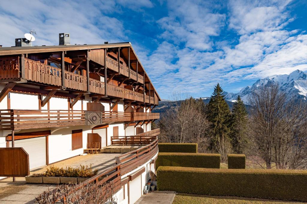 un bâtiment avec un balcon donnant sur les montagnes en arrière-plan dans l'établissement Appartement vue Mont Blanc, à Saint-Gervais-les-Bains