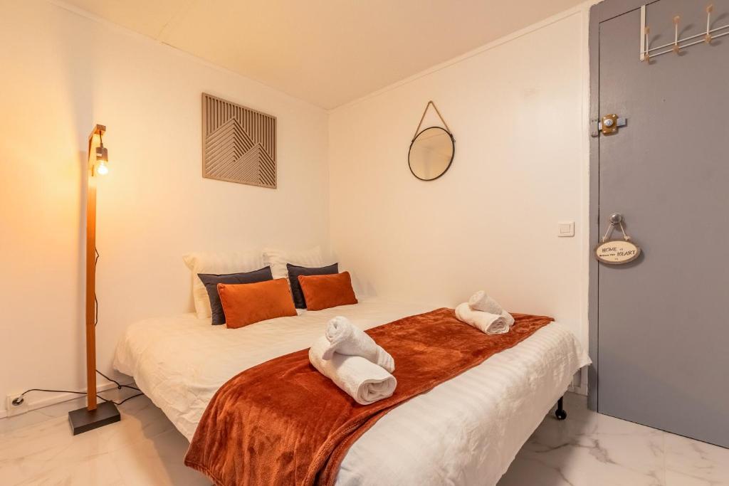 une chambre avec un lit avec des serviettes dessus dans l'établissement Le petit studio du stadium avec parking gratuit, à Villeneuve d'Ascq