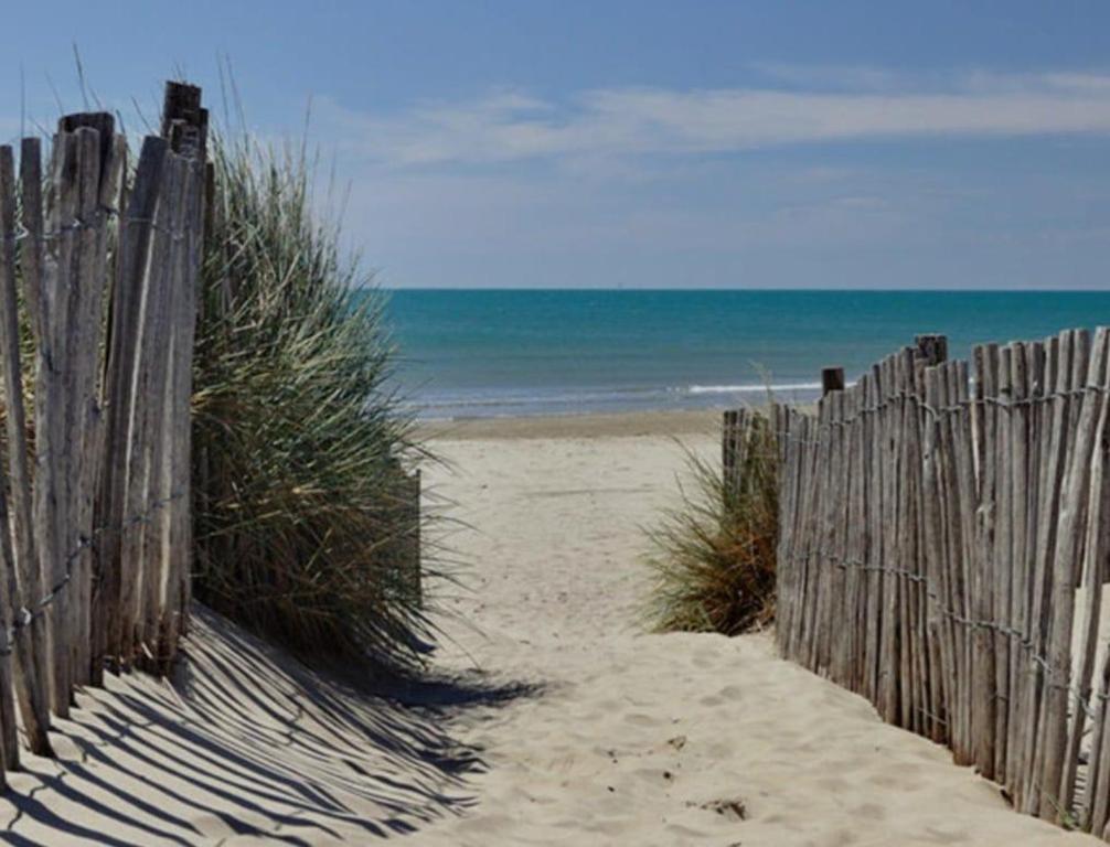 une clôture en bois sur une plage près de l'océan dans l'établissement Chez Jojo, 250m de la plage, wifi & climatisation, à Canet