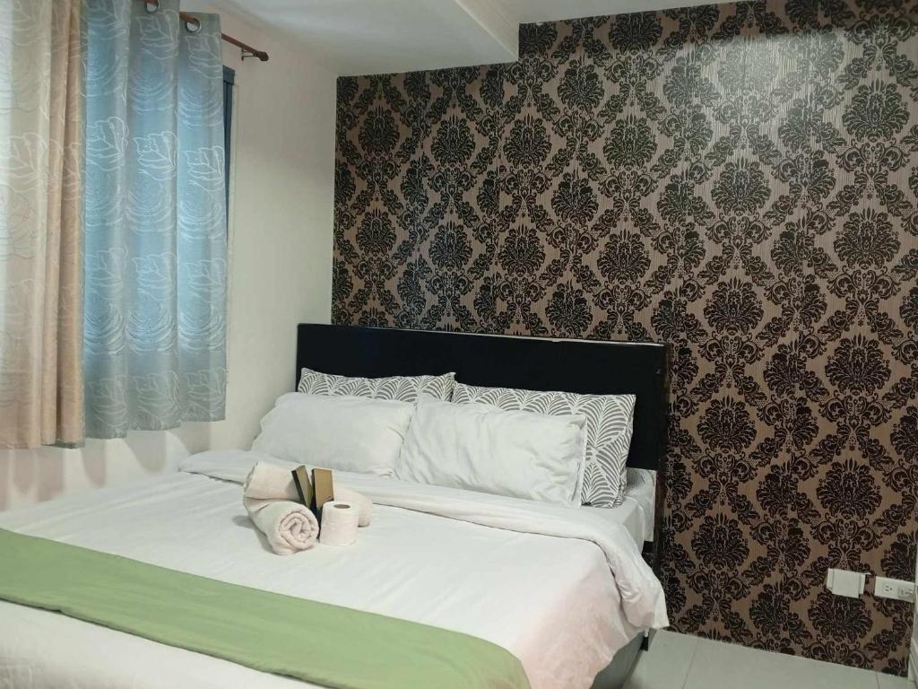 ein Schlafzimmer mit einem Bett mit zwei Handtüchern darauf in der Unterkunft Grand Riviera suite Condotel in Manila