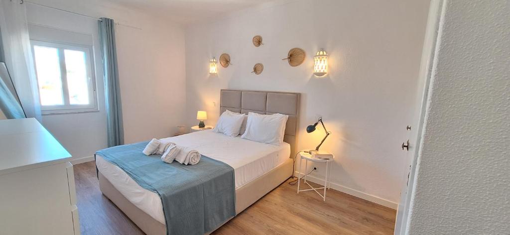 una camera da letto con un letto con due asciugamani sopra di Timi's House - Espaçoso apartamento a 350 m da praia e centro da cidade velha ad Albufeira