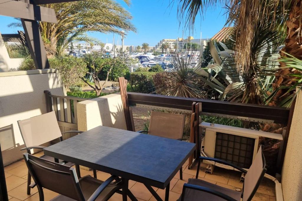 une table et des chaises sur un balcon avec vue dans l'établissement Naturiste Cap d'Agde Port Vénus 7, au Cap d'Agde