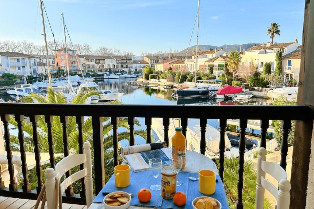 - une table avec de la nourriture sur un balcon avec un port de plaisance dans l'établissement Lovely 3-room apartment with AC and WIFI - Lift, à Grimaud
