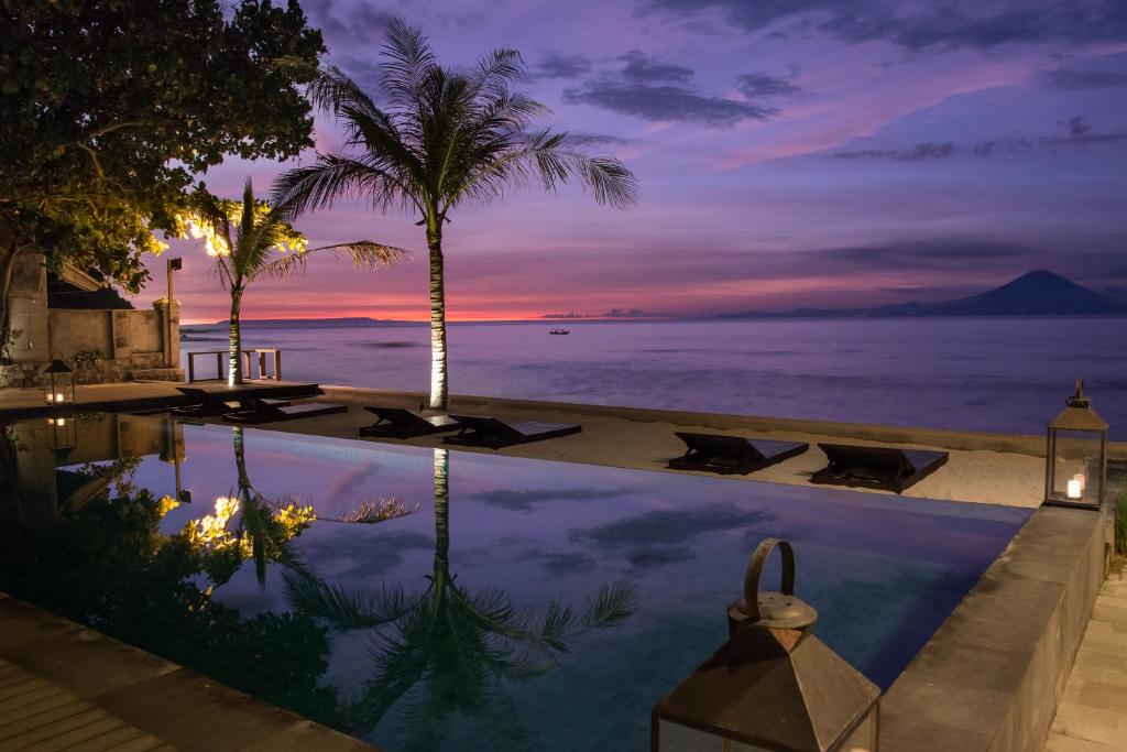 einen Pool mit Meerblick in der Nacht in der Unterkunft Jeeva Santai Villas in Senggigi 