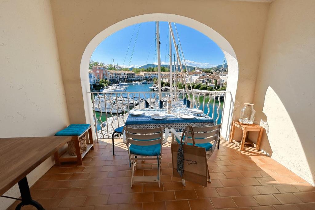 a balcony with a table and a view of a marina at This comfortable and bright apartment WIFI in Grimaud