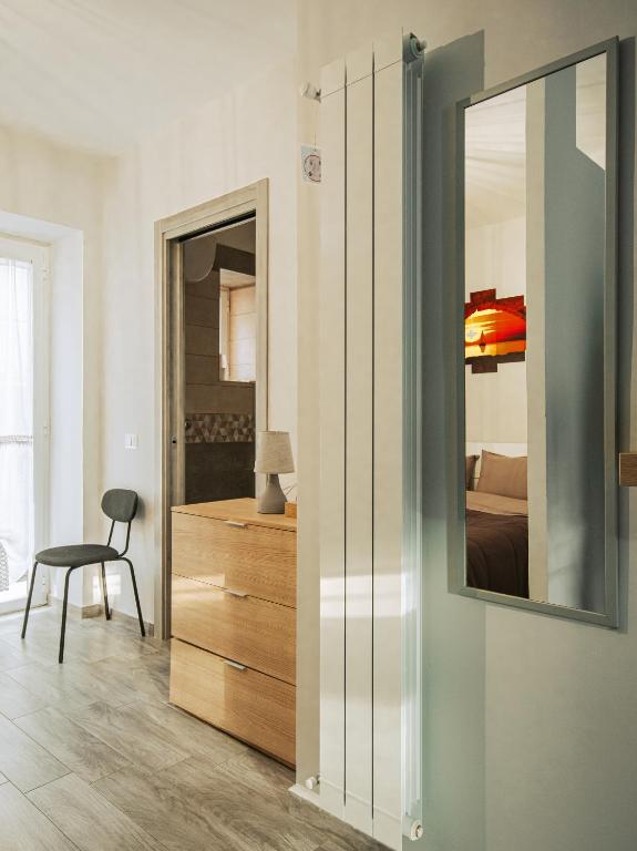 a bedroom with a mirror and a bed and a chair at Free Parking - Da Raf in Marano di Napoli