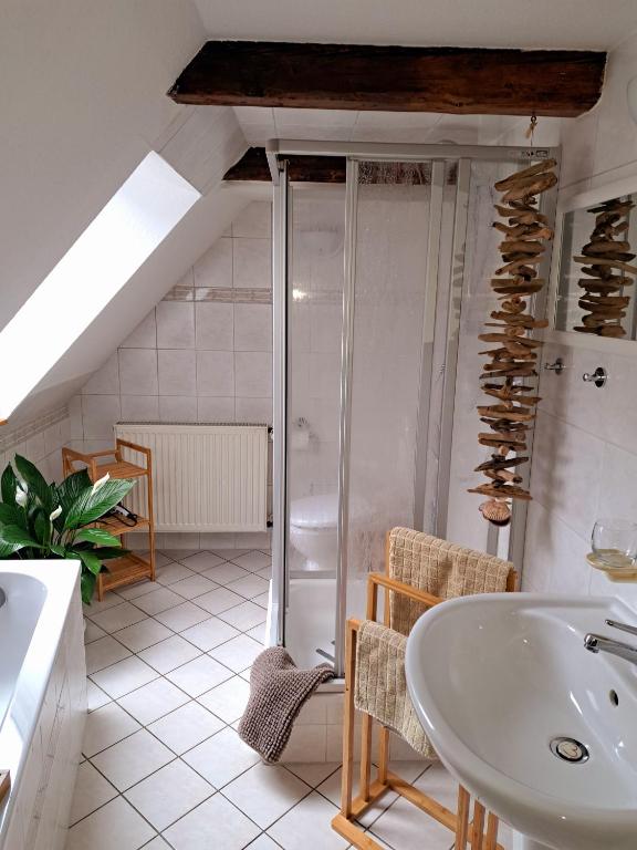 a bathroom with a sink and a bath tub at Dachstübchen mit 2 Zimmern in Boizenburg