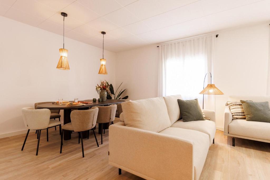 a living room with a white couch and a table at Bravissimo Maragall, very spacious and central in Girona