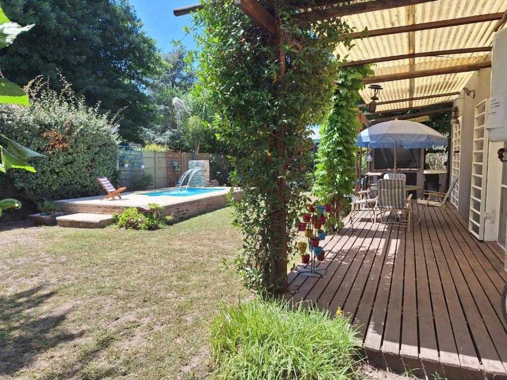 una terraza de madera con hiedra creciendo alrededor de ella junto a una piscina en Casa en Laguna de Lobos, en Lobos