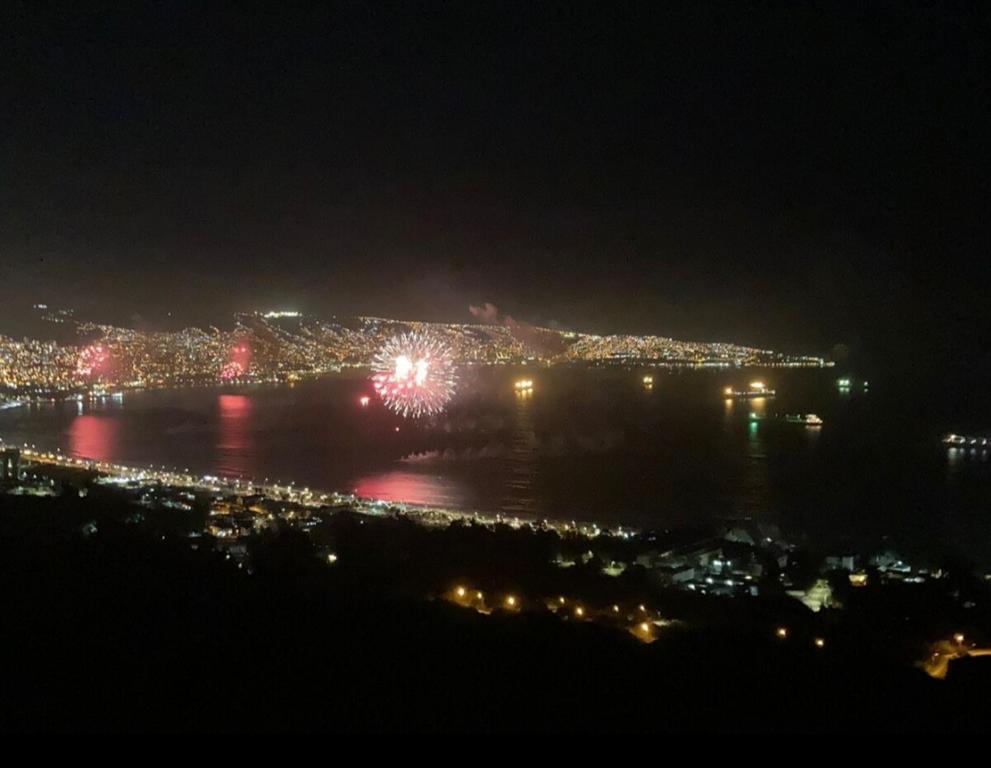 Una vista de una ciudad de noche con fuegos artificiales. en My House is Yours Espectacular Departamento Vista al Mar Temporada Verano, en Viña del Mar