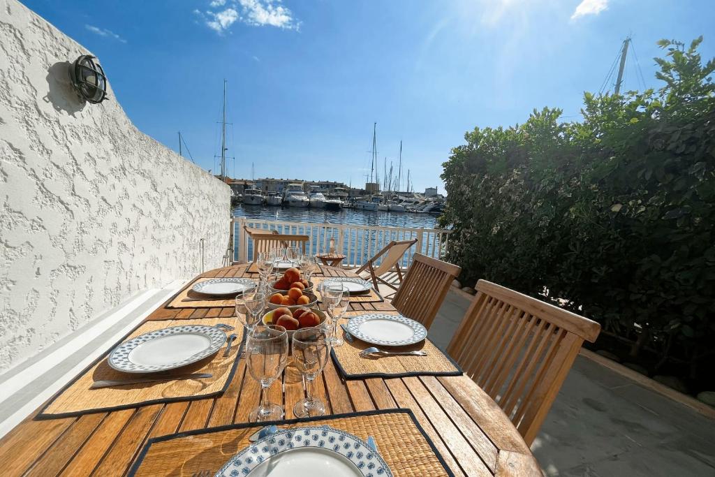une table en bois avec des assiettes et des bols de fruits dans l'établissement Beautiful fisherman house and a mooring - WIFI, à Grimaud
