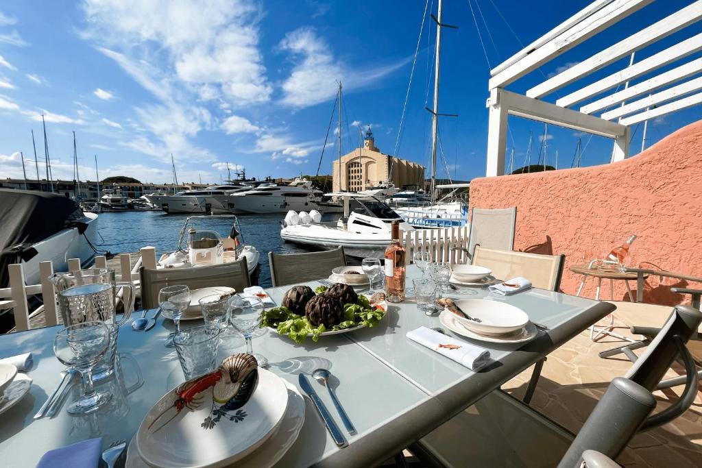 - une table avec une assiette de nourriture sur un balcon avec des bateaux dans l'établissement Fisherman house with WIFI AC and a 14m-mooring, à Grimaud