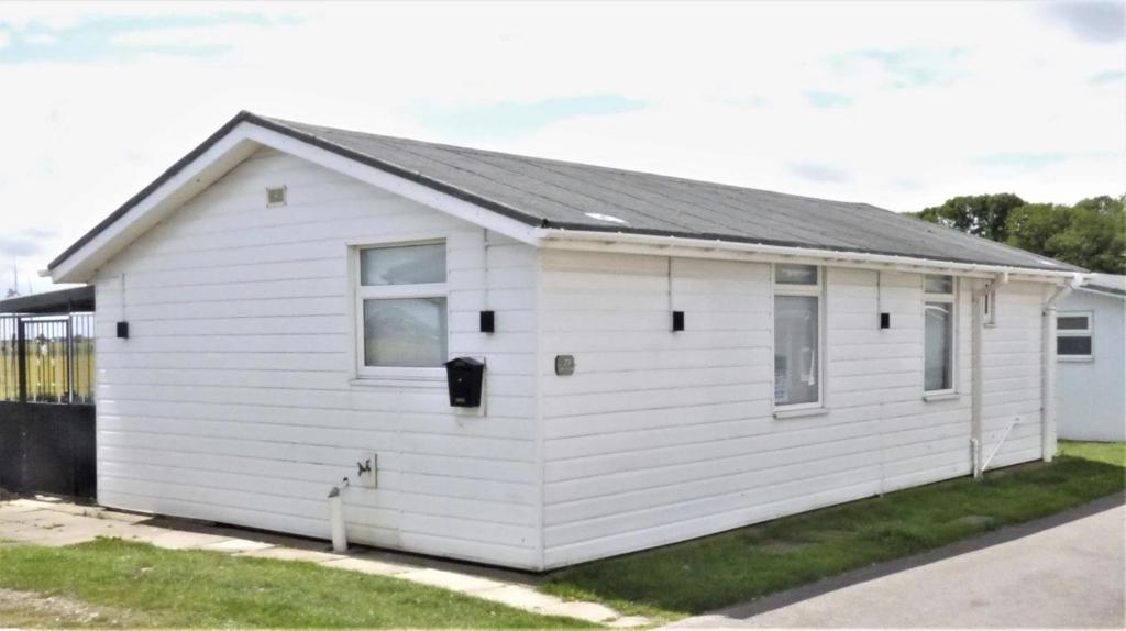 een wit gebouw met een grijs dak bij 3 Bedroom Detached Holiday Chalet SouthShore Park in Bridlington