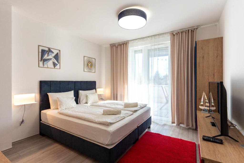 a bedroom with a large bed and a television at Sunset Resort 109 in Fonyód