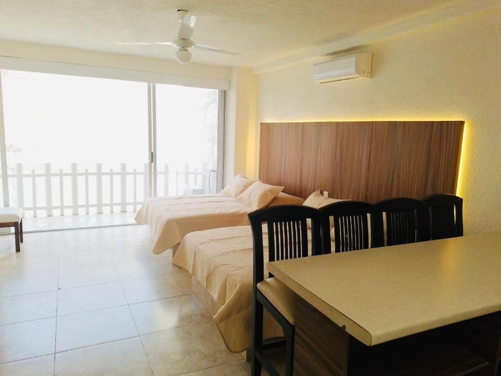 een hotelkamer met een bed, een tafel en stoelen bij SKY Acapulco Y condominio mediterrane in Acapulco