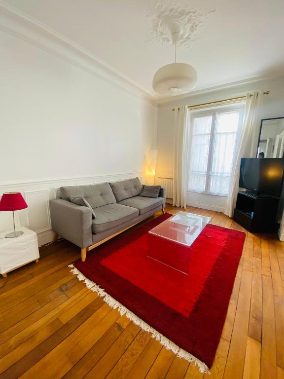 un salon avec un canapé et un tapis rouge dans l'établissement Motte Picquet théâtre Paris, à Paris