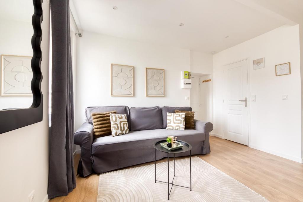 un salon avec un canapé et une table dans l'établissement Studio aux Porte de Paris, à Gentilly