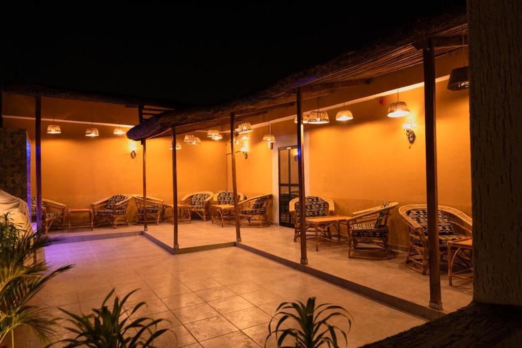 a patio with tables and chairs at night at Airport INN Hotel in Lomé