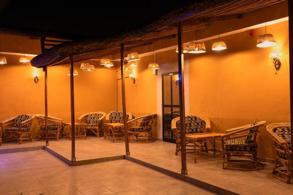 a dining room with tables and chairs and lights at Airport INN Hotel in Lomé