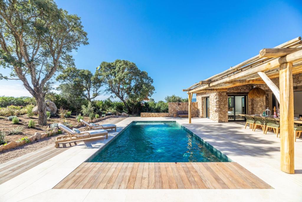 an image of a swimming pool with a house at Bergerie luxe moderne LOU TERRA in Figari