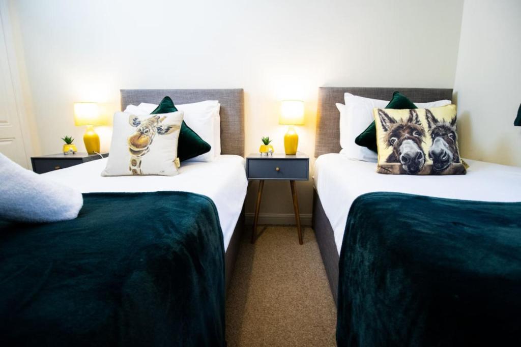 two twin beds in a hotel room with pillows at Brunel Apartment, Sleeps 4, 2 Bedrooms, Free parking, Long stay disc in Swindon