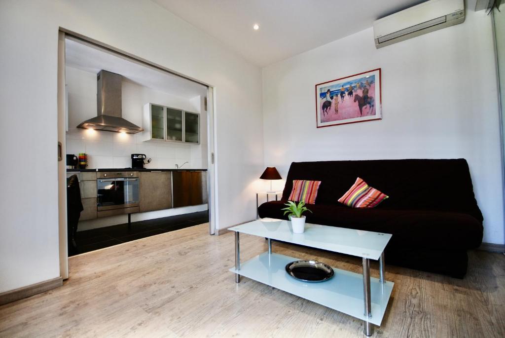 un salon avec un canapé noir et une table dans l'établissement Le Gambetta 2P 262, à Cannes