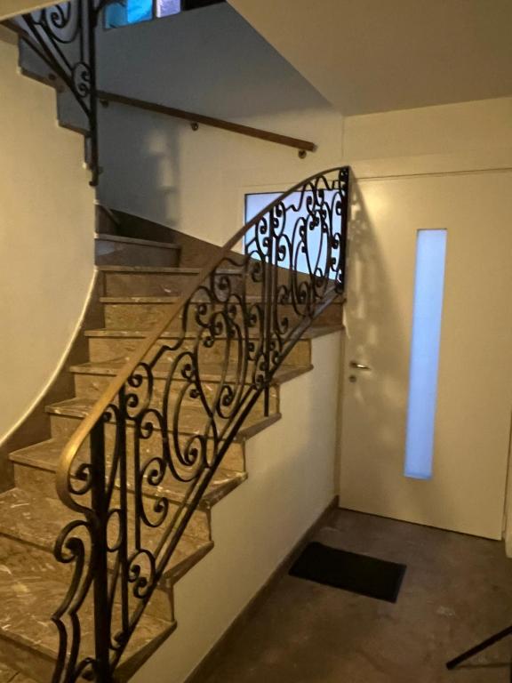 una scala con ringhiera in ferro battuto accanto a una porta di Cœur de ville a Lens