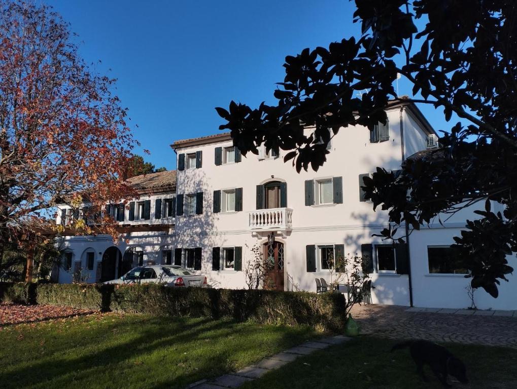 a large white house with a car parked in front at Villa Ca Bruna Holiday House in San Giorgio di Livenza